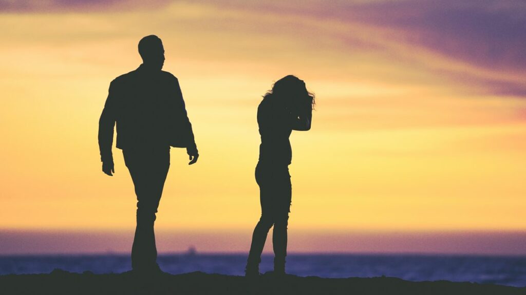 silhouette of man and woman under yellow sky