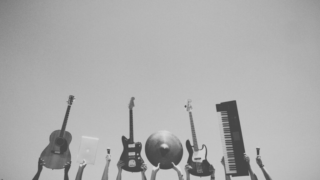 grayscale photo of people holding assorted music instruments